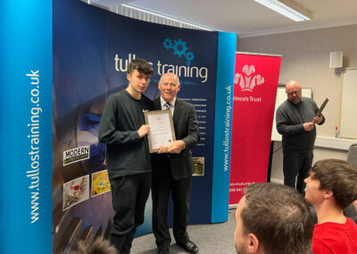 Alfie Stuart accepts his certificate from Iain Garrett, CEO at Tullos Training Ltd
