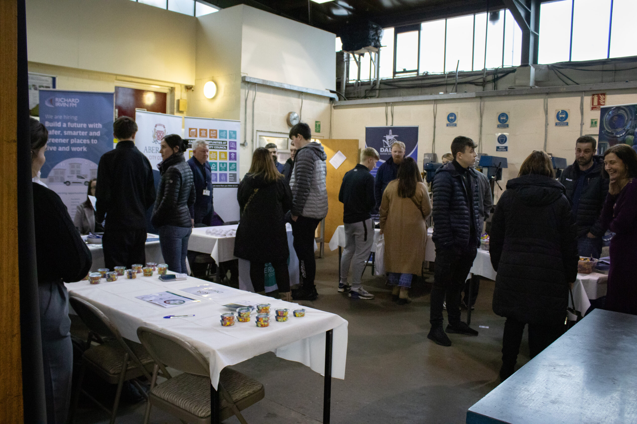 Image shows visitors attending the Tullos Training Careers Fair networking with some of the exhibitors who attended the event.