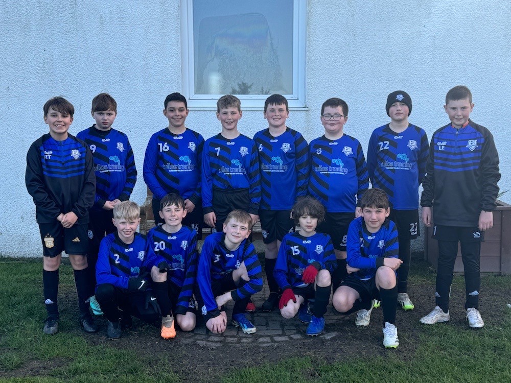 The Newtonhill Community Club 2012 year group team are pictured on grass in front of a white building.